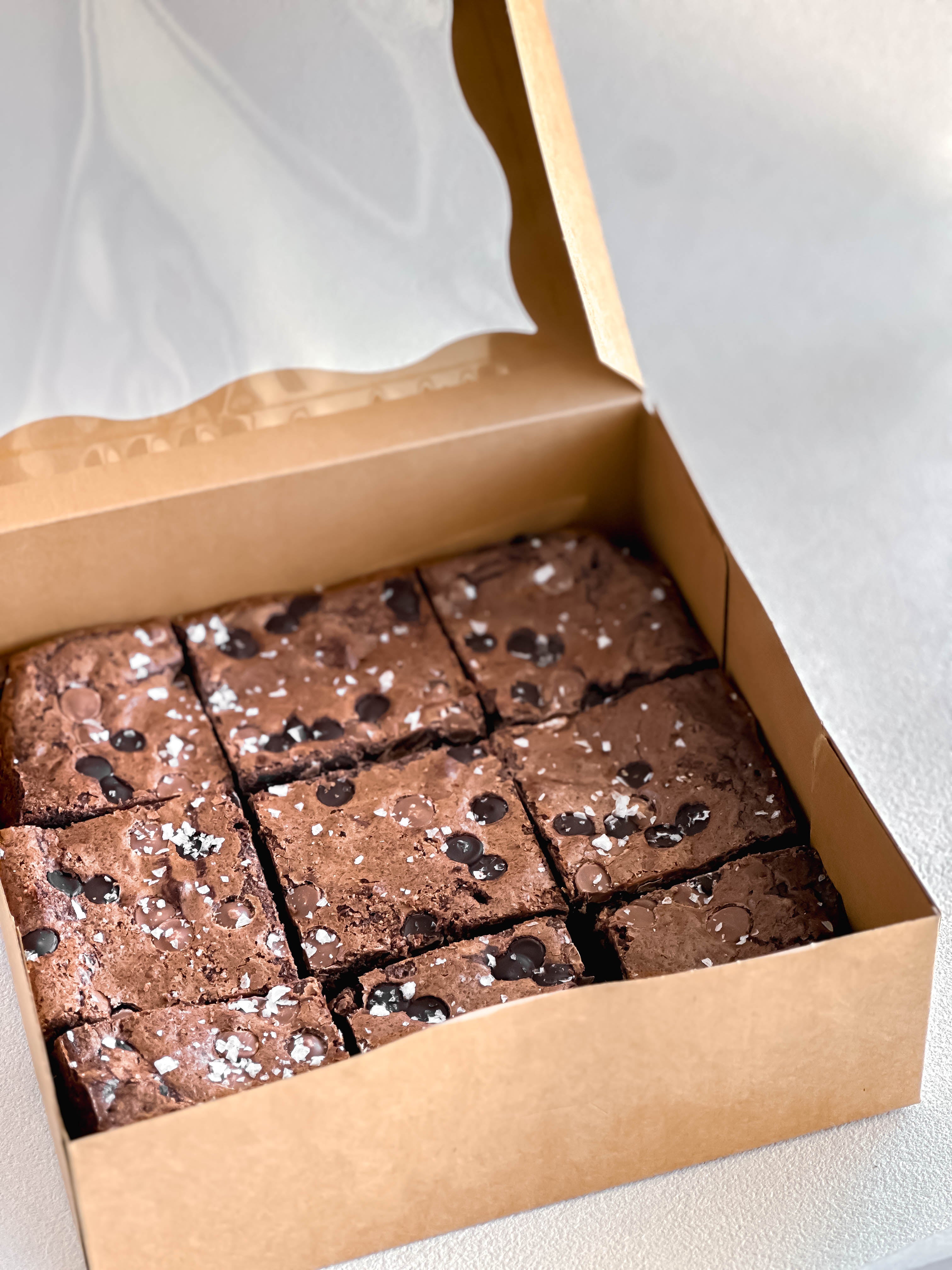 Box of brownies with chocolate chips on a white background.