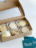 Box of assorted alfajores on a white surface.